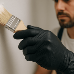 painter using black nitrile gloves to paint a wall and room