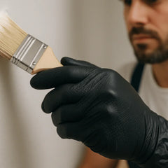 painter using black nitrile gloves to paint a wall and room