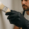 painter using black nitrile gloves to paint a wall and room